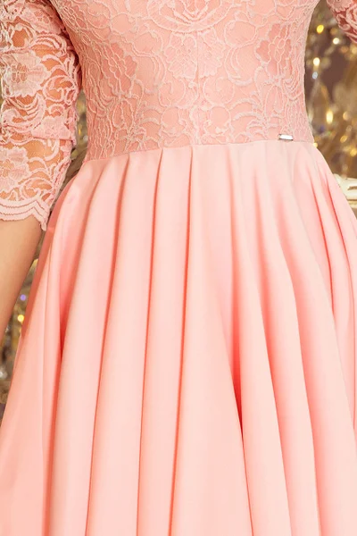 NICOLLE - Dámské šaty v pastelově růžové barvě s delším zadním dílem a s krajkovým výstřih